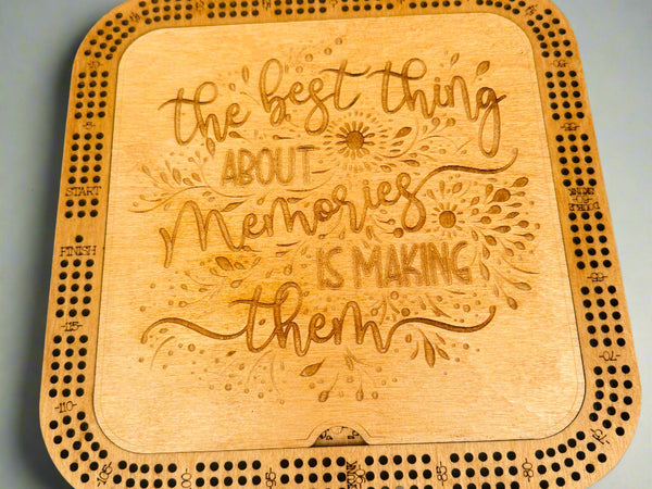 Wooden cribbage board with engraved text on a gray background