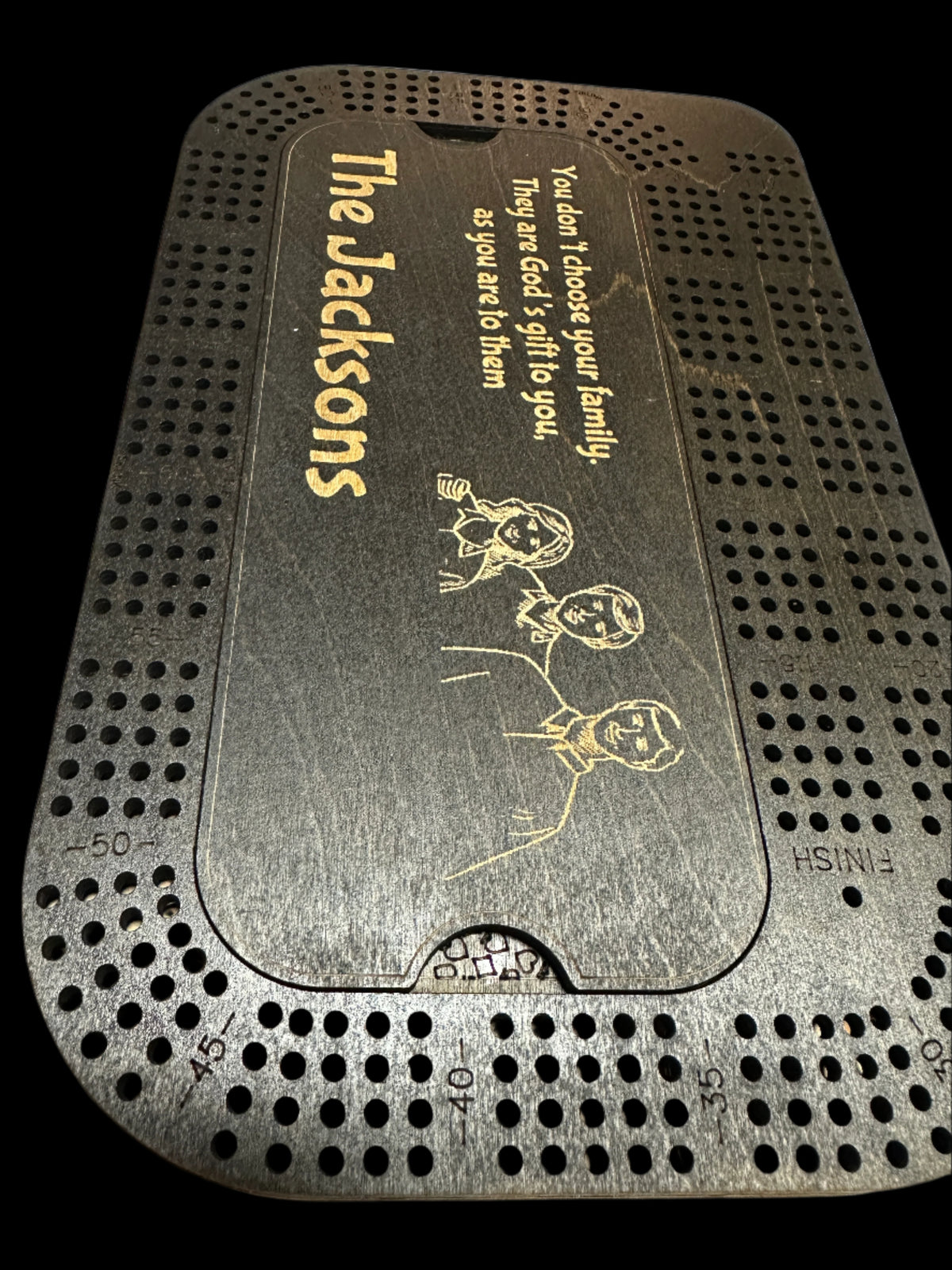 black stainedcribbage board with image of a family engraved