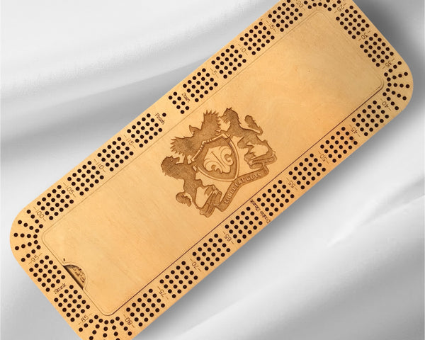Wooden cribbage board with a crest design on a gray background