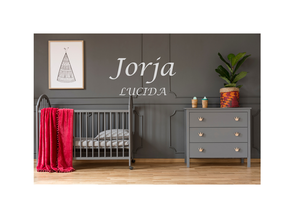 Nursery room with gray crib and dresser, red blanket, and decorative items.