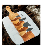 Marble cutting board with wooden handles and four cheese tools on a rustic background