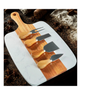 Marble cutting board with wooden handles and four cheese tools on a rustic background