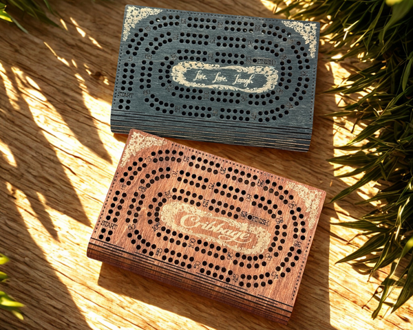 Two wooden cribbage boards on a wooden surface with plants in the background