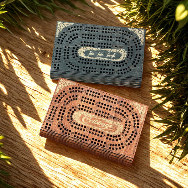 Two wooden cribbage boards on a wooden surface with plants in the background