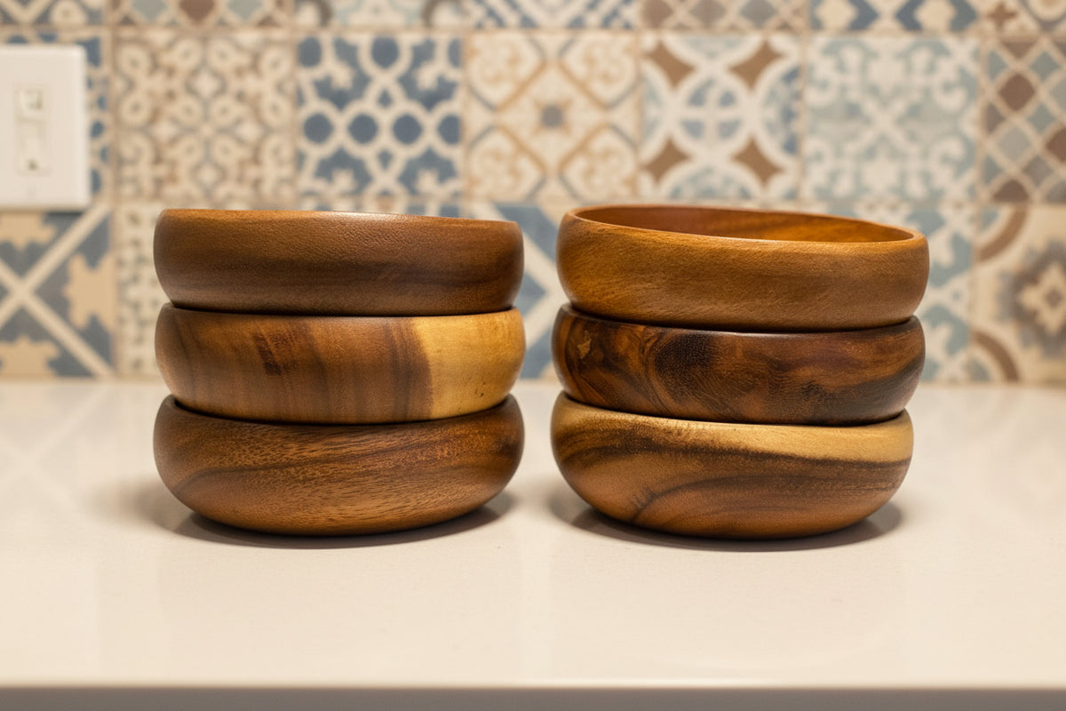 Stacks of wooden bowls on a surface with a patterned wall in the background