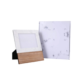 Wooden photo frame and marble-patterned paper on a white background