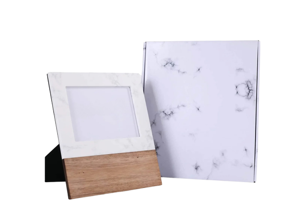 Wooden photo frame and marble-patterned paper on a white background