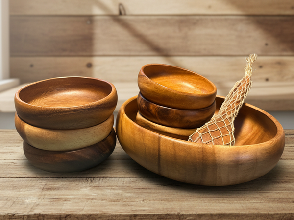 Set of wooden bowls on a wooden surface with a wooden wall background