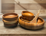 Set of wooden bowls on a wooden surface with a wooden wall background