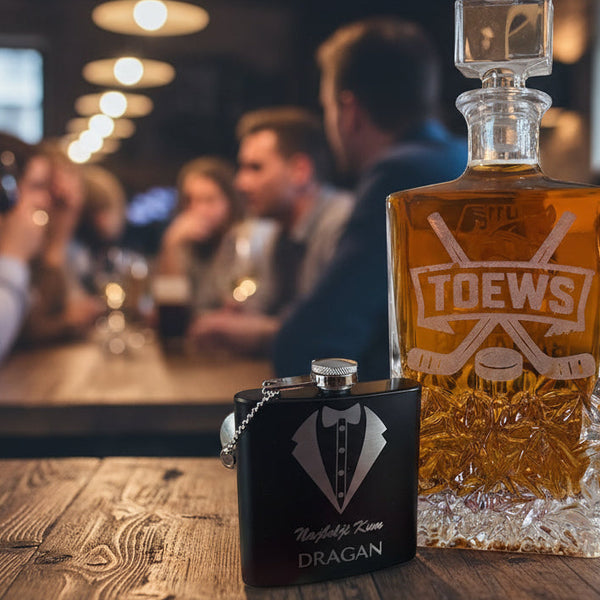 Bottle of amber liquid with 'TOEWS' branding and a black flask on a textured surface.