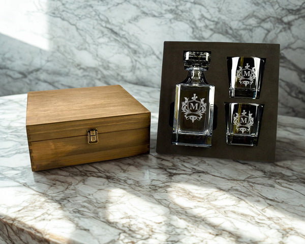 Alcohol decanter and shot glasses with wooden box on marble surface