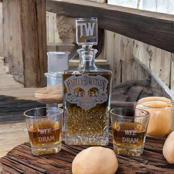 Harley Davidson whiskey bottle with two glasses on a wooden surface