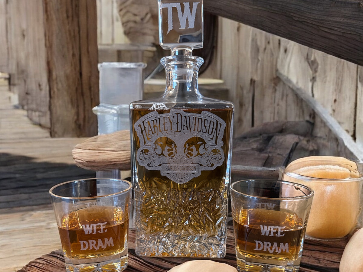 Harley Davidson whiskey bottle with two glasses on a wooden surface
