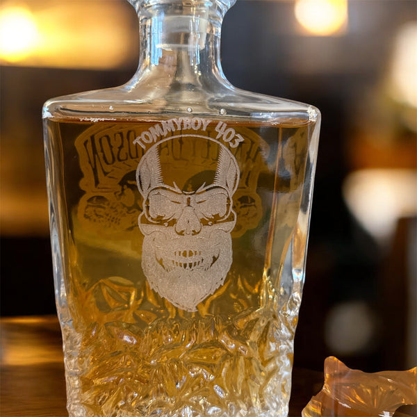 Glass bottle with engraved design and text on a blurred background