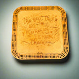 Wooden coaster with engraved text on a gray background