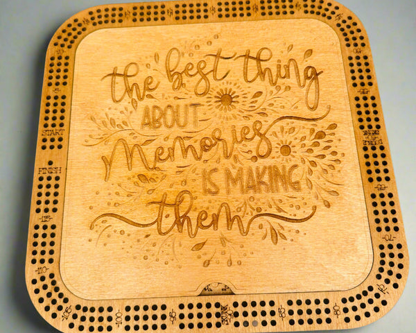 Wooden cribbage board with engraved text on a gray background
