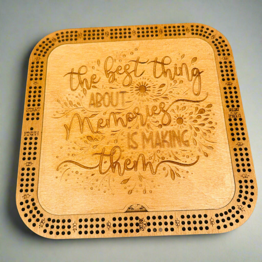 Wooden cribbage board with engraved text on a gray background