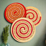 Three circular wooden coasters with spiral designs on a beige background