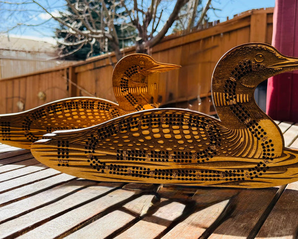 Wooden duck sculpture on a wooden surface outdoors