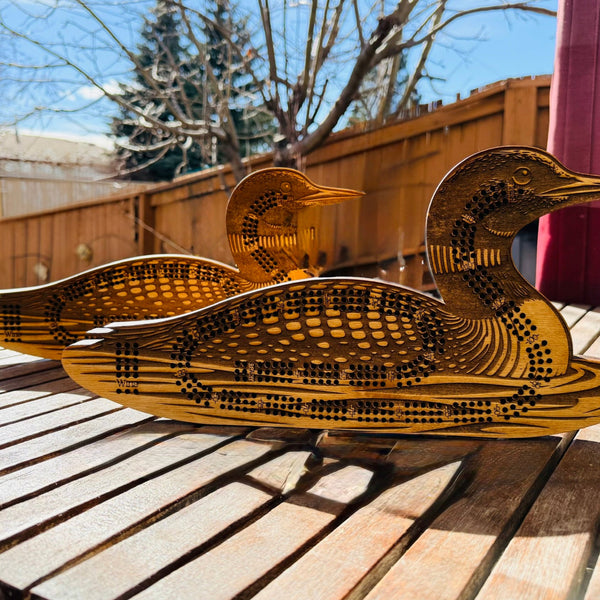Wooden duck sculpture on a wooden surface outdoors