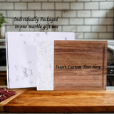 Wooden cutting board with marble gift box on a kitchen counter
