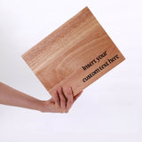 Wooden cutting board with 'Insert your custom text here' text, held by a hand on a white background