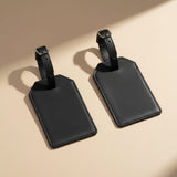 Two black leather luggage tags on a white background