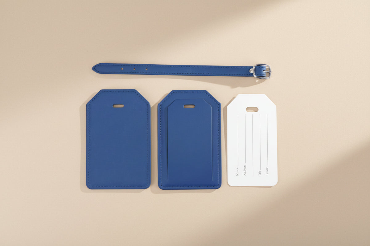 Two blue luggage tags and a belt on a white background