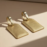 Two gold leather luggage tags on a white background