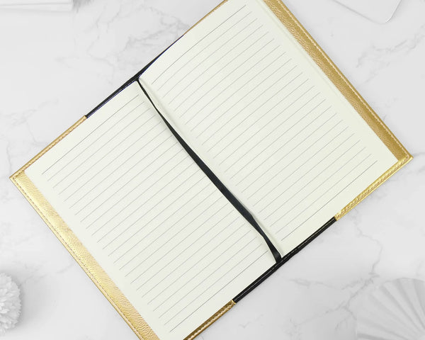 Open notebook with gold edges on a white background