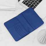 Blue wallet on a white surface with a laptop in the background