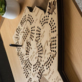 Wooden coffee table with decorative item, gray sofa, and potted plants in a living room setting.