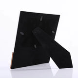 Black suede shoes with wooden soles on a white background