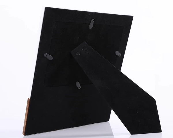 Black suede shoes with wooden soles on a white background