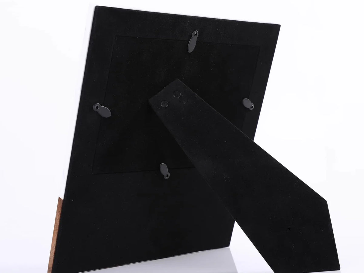 Black suede shoes with wooden soles on a white background