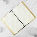 Open notebook with gold edges on a white background