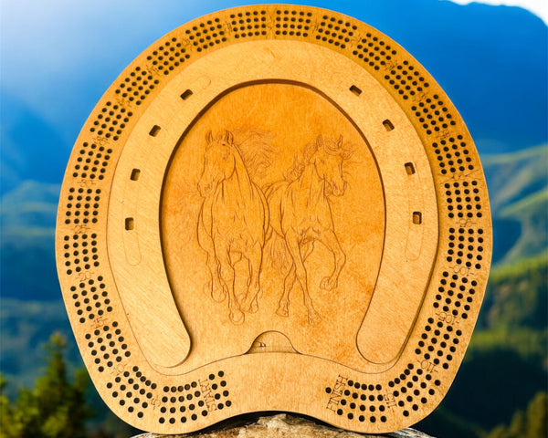 Wooden cribbage board with horse design on a rock with mountain background