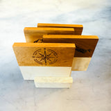 Set of wooden coasters with compass design on a marble surface