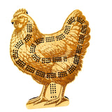 Gold-colored chicken-shaped object with black dot patterns on a white background