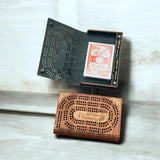 Wooden cribbage board with cards on a light wooden surface