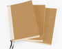 Three brown notebooks with white pages on a white background