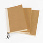 Three brown notebooks with white pages on a white background