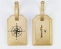Two gold luggage tags with compass design and text on a white background