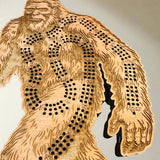 Wooden Bigfoot cribbage board with cut-out design on a light background