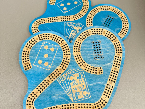 Blue cribbage board with card illustrations on a gray background