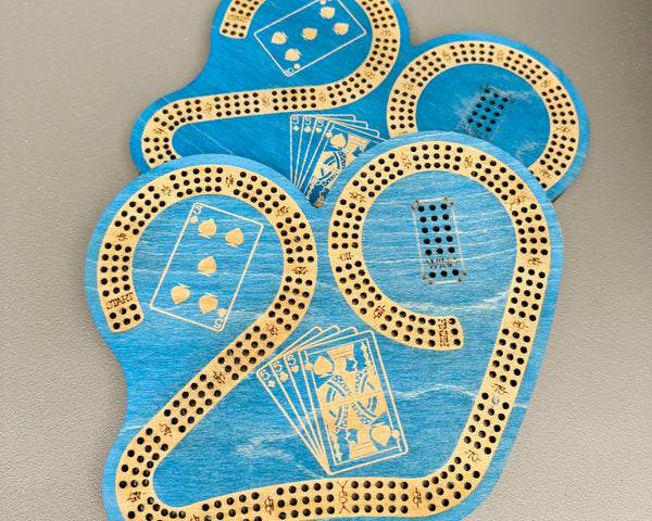 Blue cribbage board with card illustrations on a gray background