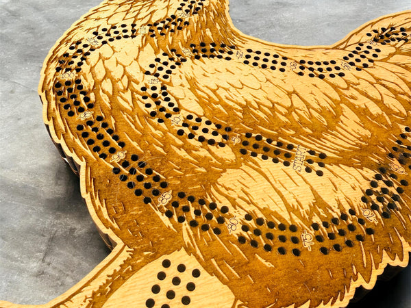 Wooden game board shaped like a rooster on a gray surface