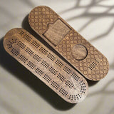 Wooden cribbage board with pegs on a gray background