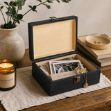 Wooden jewelry box with photos and a candle on a wooden surface