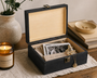 Wooden jewelry box with photos and a candle on a wooden surface